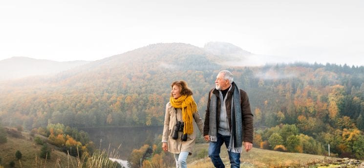 Senior couple on a walk in an autumn nature.