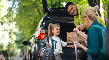 Family packing trunk at a park