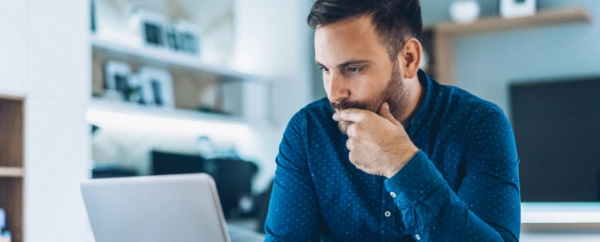A man sitting at his computer and thinking.