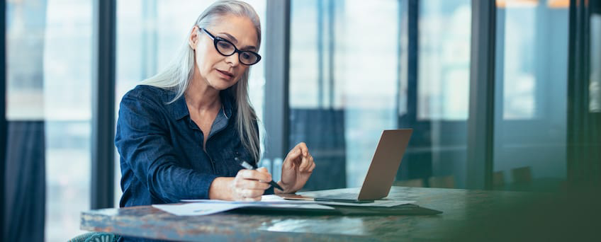 A woman looking over paperwork at a desk