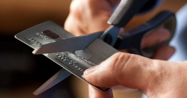 A scissor cutting through a credit card.