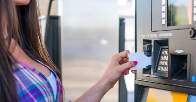 Woman using credit card at gas pump